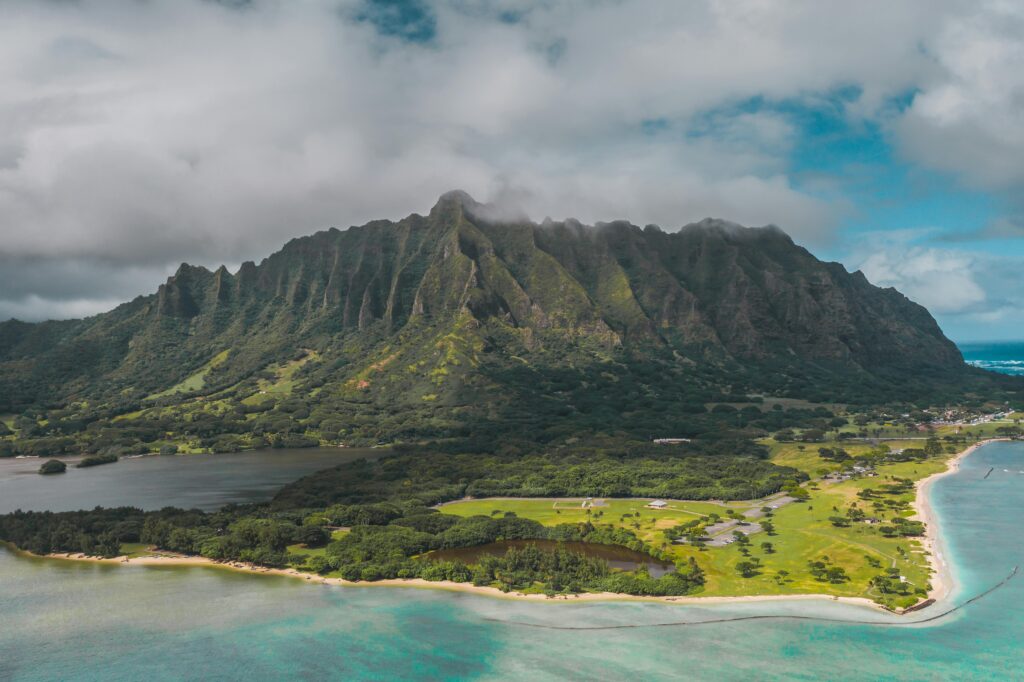 Stunning aerial view of Hawaii's lush landscape with mountains, coastline, and sea.