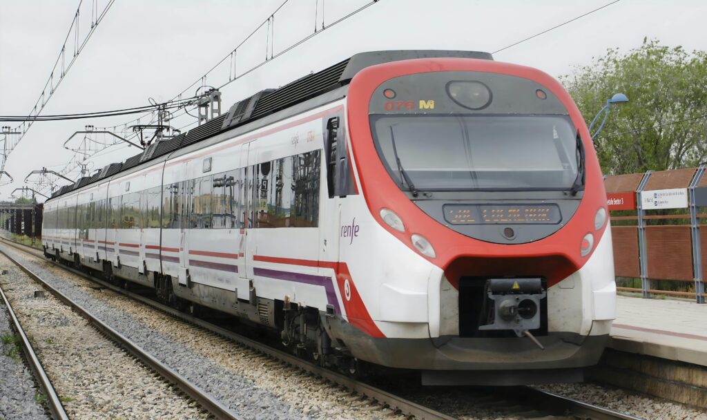 A sleek commuter train arrives at a Madrid station, showcasing modern transportation.
